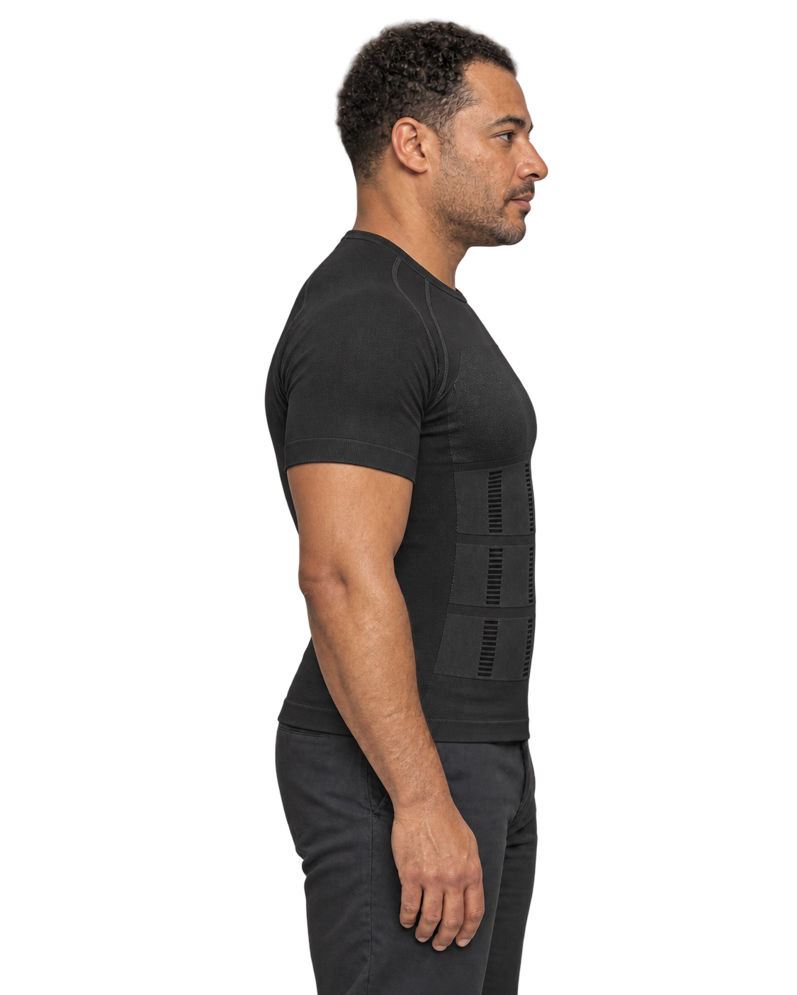 Le même modèle en t-shirt noir à panneaux de compression, ventre visuellement lissé et posture redressée — visuel retouché.