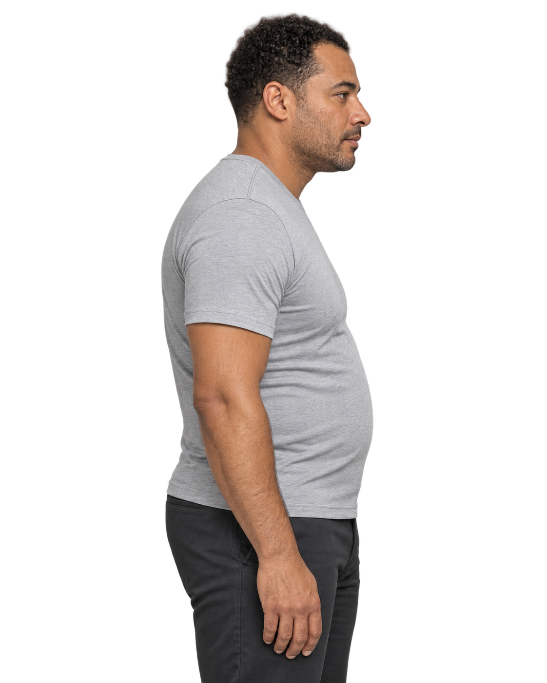 Modèle de profil, posture relâchée et ventre arrondi, portant un t-shirt gris.